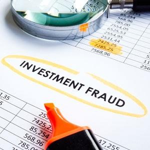 Investment fraud highlighted on financial documents with magnifier.